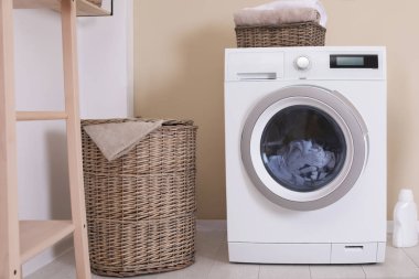 Çamaşırhane odası iç duvarının yakınında çamaşır makinesi ile