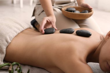 Güzel ve genç birbayan Başlarken sıcak taş spa salonda masaj