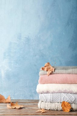 Sonbahar ile sıcak giysiler yığını üzerinde ahşap masa bırakır. Metin için yer