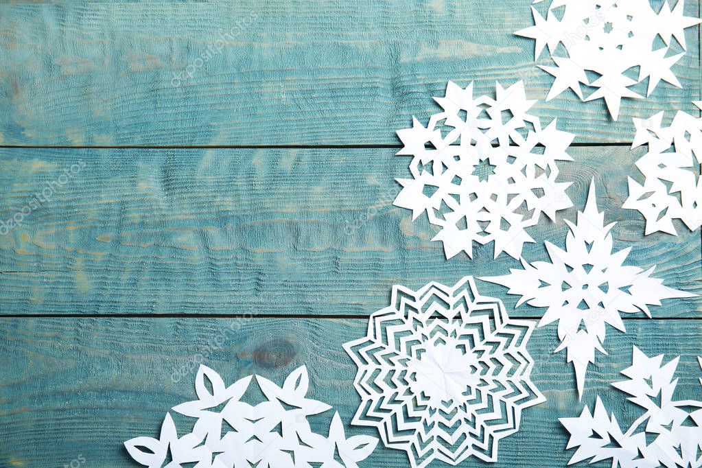 Composition with snowflakes and space for text on wooden background, top view. Festive winter design