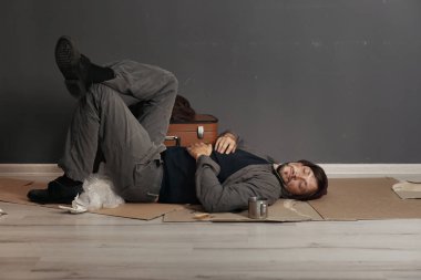 Zavallı evsiz adam karanlık duvarının yakınında katta uyuyor