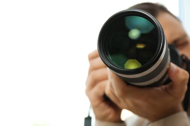 Erkek fotoğrafçı ile beyaz arka plan üzerinde profesyonel fotoğraf makinesi. Metin için yer