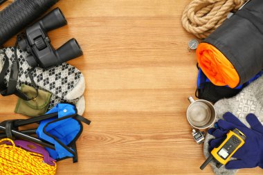 Uyku tulumu ve kamp malzemeleri ahşap arka plan üzerinde düz yatıyordu kompozisyonu. Metin için yer