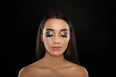 Kirpik uzantıları ve siyah arka plan üzerine güzel makyaj ile genç kadın portresi