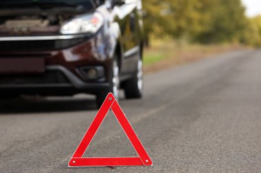 Acil dur işareti yakınındaki yolda kırık araba. Otomatik sigorta