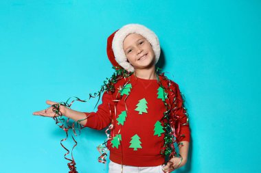 El yapımı Noel kazağı ve şapka renk arka plan üzerinde flamalar ile şirin küçük çocuk