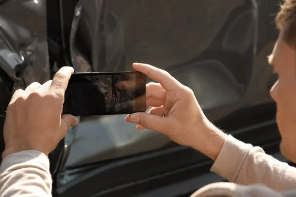 保険金請求書 クローズ アップのために事故後の壊れた車を撮影する男 — ストック写真