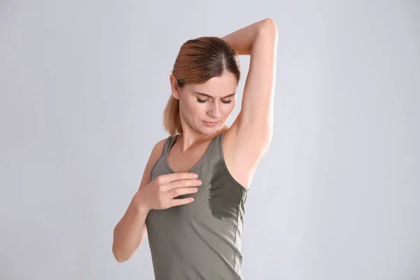 Jonge Vrouw Met Zweet Vlek Haar Kleren Tegen Lichte Achtergrond — Stockfoto