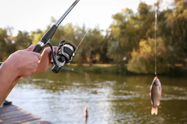 Man with rod fishing at riverside. Recreational activity