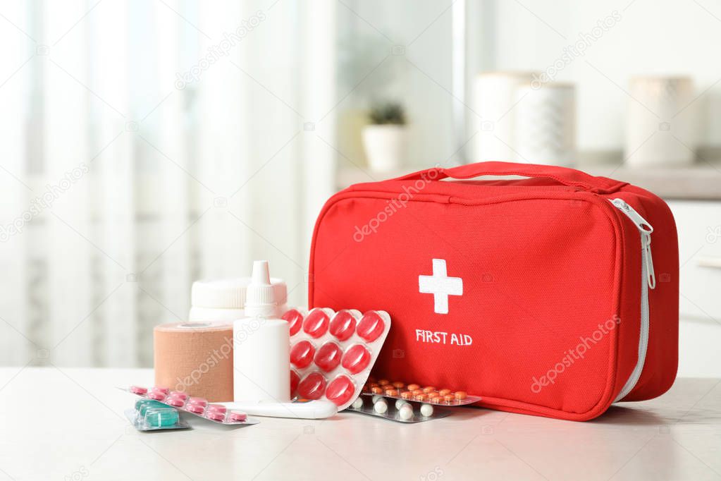 First aid kit with pills on table indoors