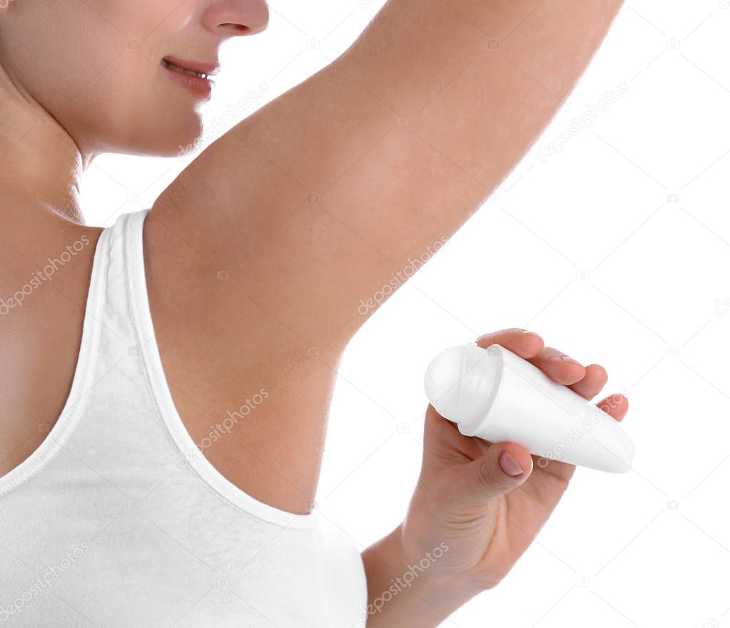 Young woman using deodorant on white background, closeup