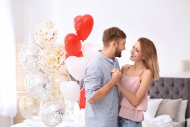 Hava balonları yatak odasında genç çift. Saint Valentine's Day kutlamaları