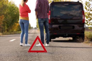 Acil dur işareti yakınındaki insanlar yolda trafik kazası tartışıyor. Otomatik sigorta
