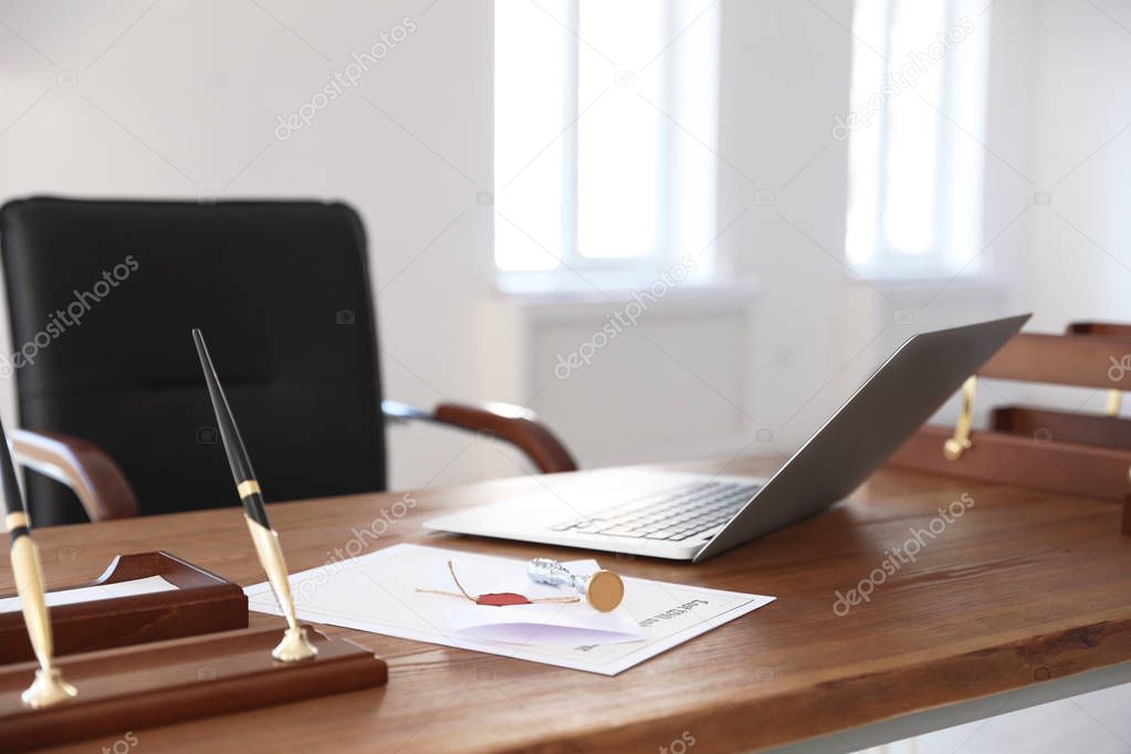 Vintage stamp, laptop and documents on desk in notary's office