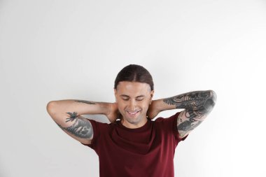 Beyaz arka plan üzerinde şık dövmeli genç adam