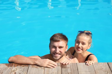 Mutlu genç çift Resort'ta yüzme havuzunda
