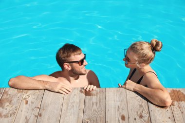 Mutlu genç çift Resort'ta yüzme havuzunda