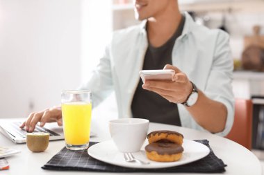 Gıda blogger ile dizüstü bilgisayar ve masada kapalı, closeup smartphone