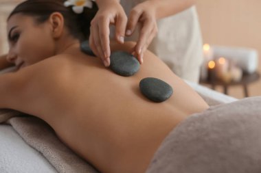 Güzel ve genç birbayan Başlarken sıcak taş spa salonda masaj