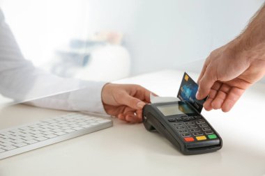 Kredi kartı ödeme nakit bölümü penceresinde, closeup banka terminal kullanan adam