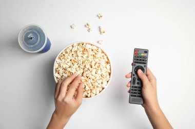 Tv beyaz zemin üzerine, üstten görünüm patlamış mısır yemek uzak olan kadın. Sinema izliyor