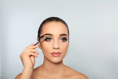 Açık renkli fırça tutan kirpik uzantıları olan kadın portresi