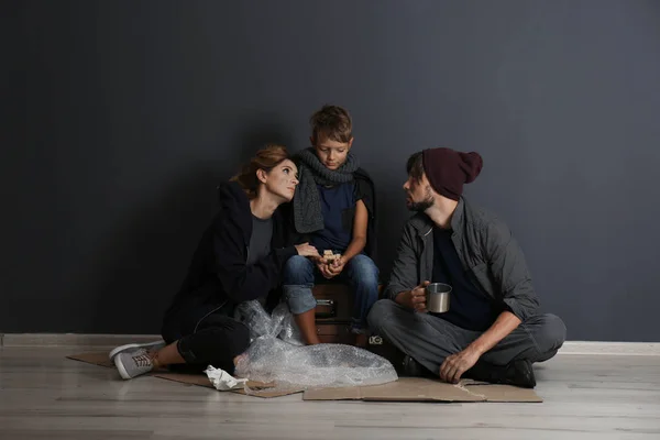 Arme Obdachlose Familie Sitzt Auf Dem Boden Neben Dunkler Wand — Stockfoto