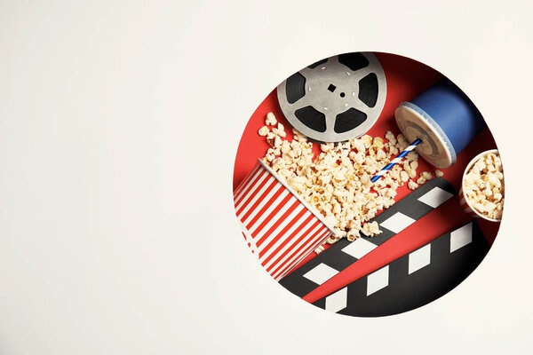 Composition with popcorn, cinema reel and space for text on color background, top view