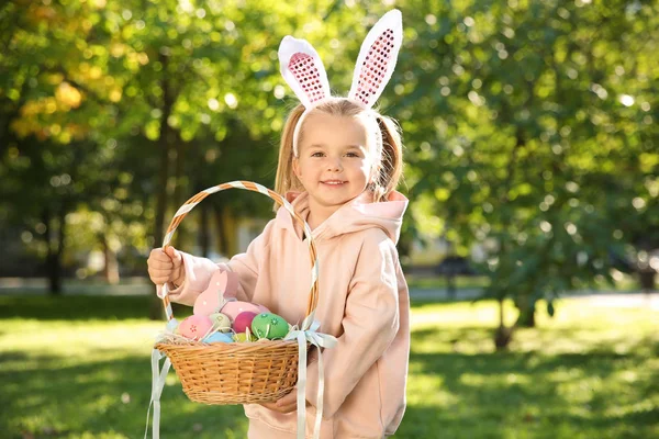Niedliches Kleines Mädchen Mit Hasenohren Und Korb Mit Ostereiern Park — Stockfoto