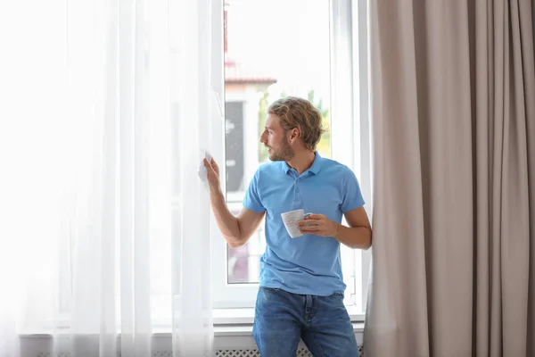 Jeune Homme Reposant Près Fenêtre Avec Des Rideaux Ouverts Maison — Photo