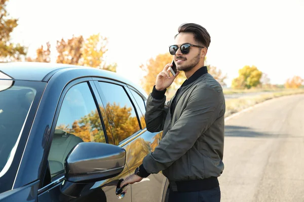 Young Man Talking Phone While Opening Car Door Outdoors — Stock Photo, Image