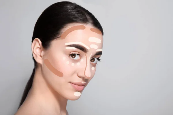 テキスト用のスペース 灰色の背景に対して顔に別の色の基礎と美しい若い女性 化粧の輪郭 — ストック写真