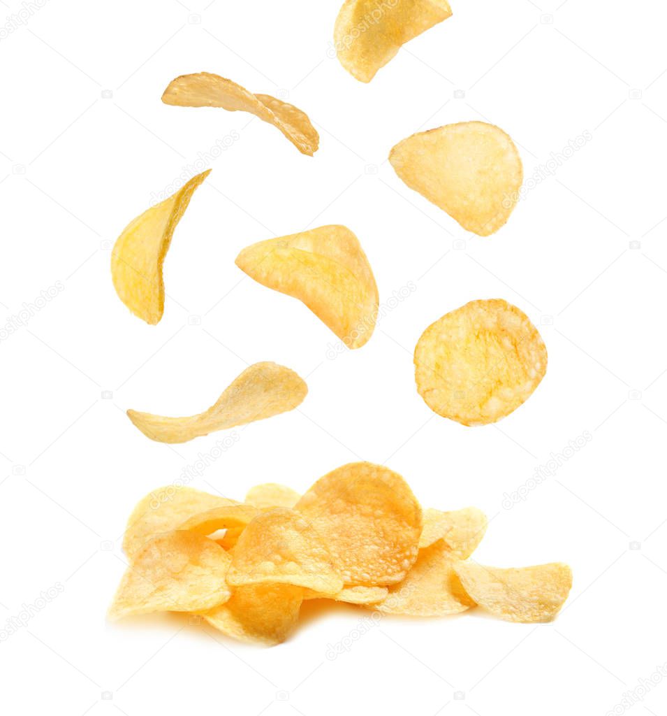 Tasty potato chips falling on white background