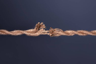 Koyu arka plan üzerinde kırma yıpranmış ip gerilmiş
