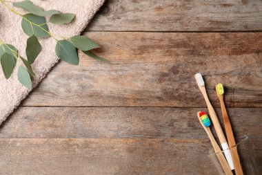 Bambu diş fırçaları ve ahşap arka plan üzerinde metin için yer düz yatıyordu kompozisyonu