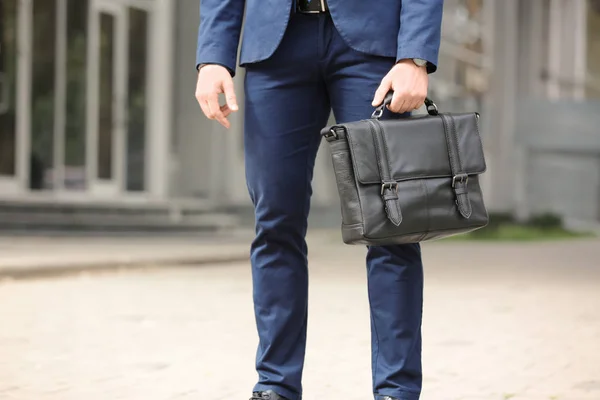 屋外の手で黒のブリーフケースを持ったビジネスマン — ストック写真
