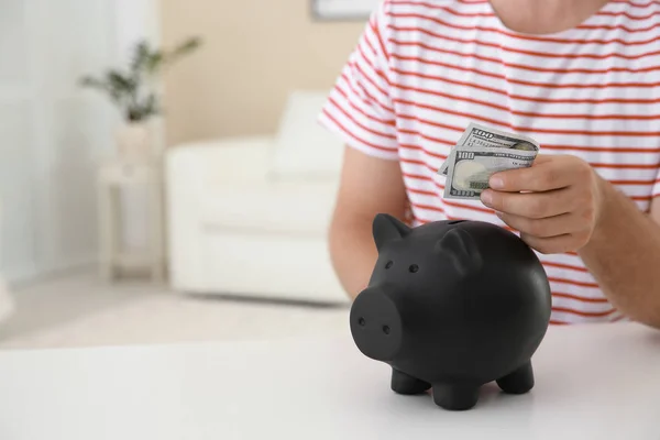 Man Geld Steken Piggy Bank Tafel Binnenshuis Ruimte Voor Tekst — Stockfoto