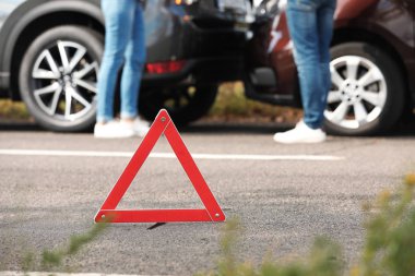 Acil dur işareti yakınındaki insanlar yolda trafik kazası tartışıyor. Otomatik sigorta
