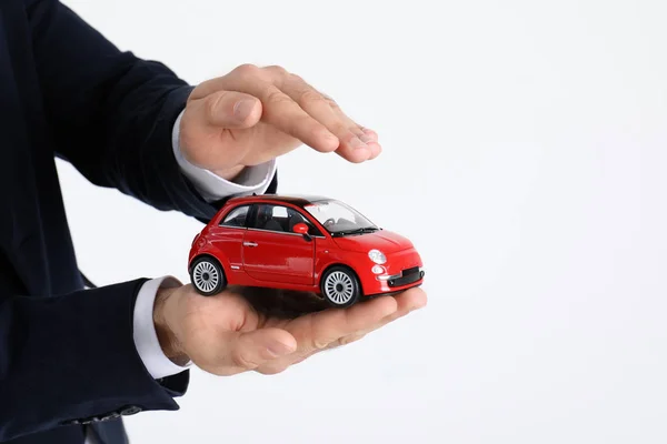 Agente Seguros Masculino Sosteniendo Coche Juguete Sobre Fondo Blanco Primer —  Fotos de Stock