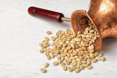 Yeşil kahve çekirdekleri ve beyaz tablodaki metin için yer ile devrilmiş jezve