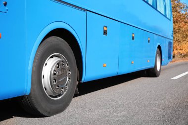 Yolda, odak üstünde tekerlek modern mavi otobüs. Yolcu taşımacılığı