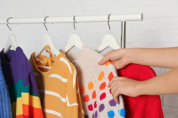 Mujer Elegir Suéter Rack Contra Pared Ladrillo Primer Plano —  Fotos de Stock