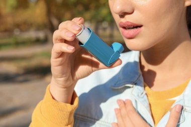 Astım inhaler açık havada kullanan kadın. Sağlık