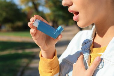 Astım inhaler açık havada kullanan kadın. Sağlık