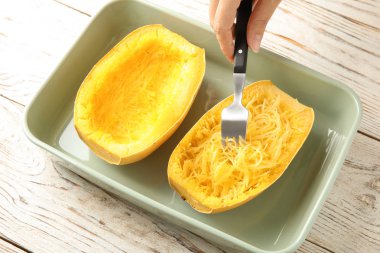 Masada çatal ile eti pişmiş spagetti Squash kazıma kadın