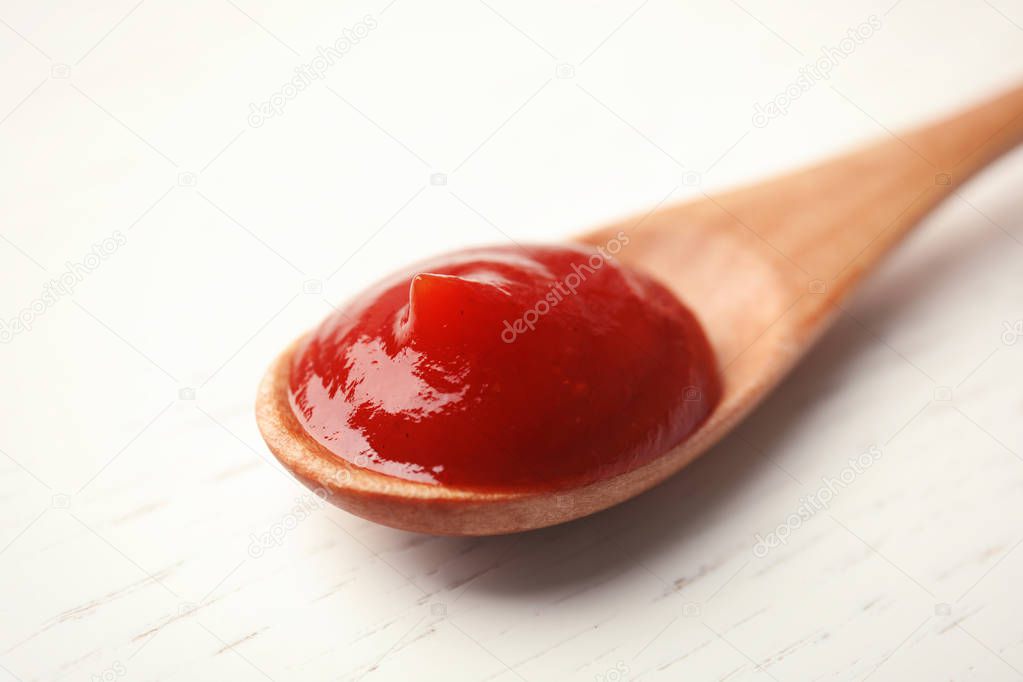 Homemade tomato sauce in spoon on wooden table