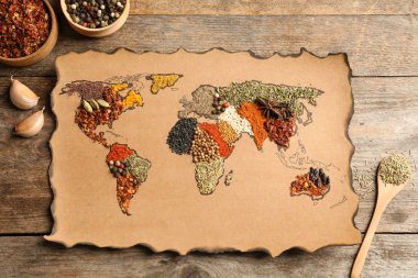 Kağıt ahşap arka plan, düz üzerinde farklı aromatik baharat yapılan Dünya Haritası ile yatıyordu