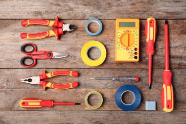 Tahta arka planda elektrikçi aletleri ile düz konum