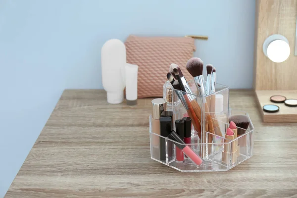 Organizer with cosmetic products for makeup on table
