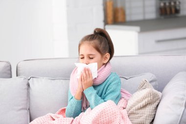 Küçük kız öksürük ve soğuk evde kanepe üzerinde acı